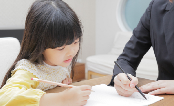 先生に教えてもらっている女の子